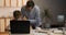 Boy sits at laptop while his father cheers him on. Father supports his son in his endeavors.