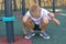 Boy sits on outdoor playground. portrait of a blonde male athlete