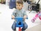 Boy sits on a plastic bicycle in the playroom. Kid's club. Rest in the children's center.