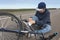 Boy sits in a road after falling from a bike, calms the pain in her knee