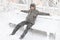 a boy sits in the snow on a bench, on a snowy street, it is snowing, a blizzard and frost on a winter day