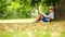Boy sits by the tree on a sunny day and reads a book