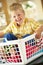 Boy Sitting In Basket Sorting Laundry