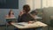 Boy sitting at desks in school class. Pensive schoolboy holding pencil in hand