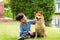 A boy is sitting with a dog by the pool. Asian boy hugging Shiba Inu in a park