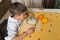 Boy sitting eating rice pudding with his left hand.