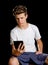 Boy sitting with ebook reader or tablet in his hand