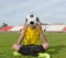 Boy sitting on the grass in a football stadium, and holds a soccer ball in front of him