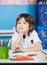 Boy Sitting With Hand On Chin In Drawing Class