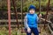 The boy sitting on the iron swing in the garden in the spring