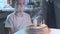 Boy sitting at kitchen table and blowing candles on birthday cake, making wish