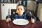 Boy sitting at the kitchen table with empty plate