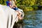 Boy sitting near father and grandfather having jeans pulled up while fishing