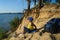 Boy sitting on sand cliff looking to sea. Travel and tourism concept