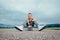 Boy sitting on skateboard on asphalt road