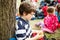 Boy sitting by a tree