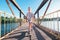 Boy skates on skate board on the bridge over tthe river