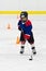 Boy skating with the puck at ice hockey practice