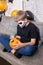 A boy in skeleton makeup paints a pumpkin for Halloween.