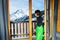 Boy in ski outfit open door to balcony with Alpine Mont Blanc