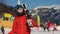 Boy at a ski resort. A child in full equipment for skiing, in a red jacket, glasses and a helmet looks at the sky. The