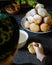 A boy in a skullcap at the table eats Kazakh baursaks. There was a bowl of tea in front of him.