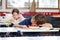 Boy Sleeping On Desk In Classroom