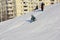 The boy is sliding down a snow hill on a sledge happily