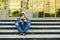 Boy with smartphone playing game outside school. Technology, internet addiction and school