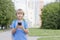 Boy with smartphone in the street. Child using apps, playing, writing or reading message. City background. School