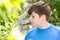 Boy smelling a lilac flowers in park