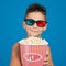 Boy smiling in 3d glasses, with a bucket of popcorn, concept of cinema and entertainment