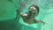 Boy smiling and swimming under water