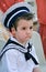 Boy with snot in his nose dressed in navy costume.