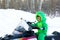 Boy is on a snowmobile in a snowy park in dragon-like outwear