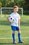 Boy soccer football player with ball on an green grass