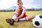 Boy, soccer player and ball with shoe laces, portrait and ready for game, shoes or child. Outdoor, exercise and sport