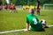 Boy soccer player on sports field. Child sitting on football grass field