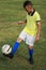 Boy soccer player in a yellow t-shirt on the soccer field juggles the ball