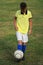 Boy soccer player in a yellow t-shirt on the soccer field juggles the ball