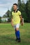 Boy soccer player in a yellow t-shirt on the soccer field juggles the ball