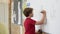 Boy solving math problem at whiteboard