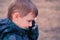 Boy speaks on a mobile phone in the Park. Close-up face, side view.