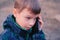 Boy speaks on a mobile phone in the Park and laughs. Front view, face close-up.