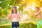 Boy splashing girl with water gun, sunny summer garden