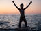 Boy splashing in sea with arms raised. Child play