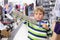 Boy in sports shop tries metal shoulder expander