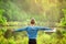 Boy spreading hands wide open on nature background.