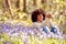 Boy In Spring Woodlands Examining Bluebells With Magnifying Glass