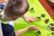 Boy squeezes the shapes from the molds on the rolled brown dough. Pressed shapes are next to prepared for bakin.